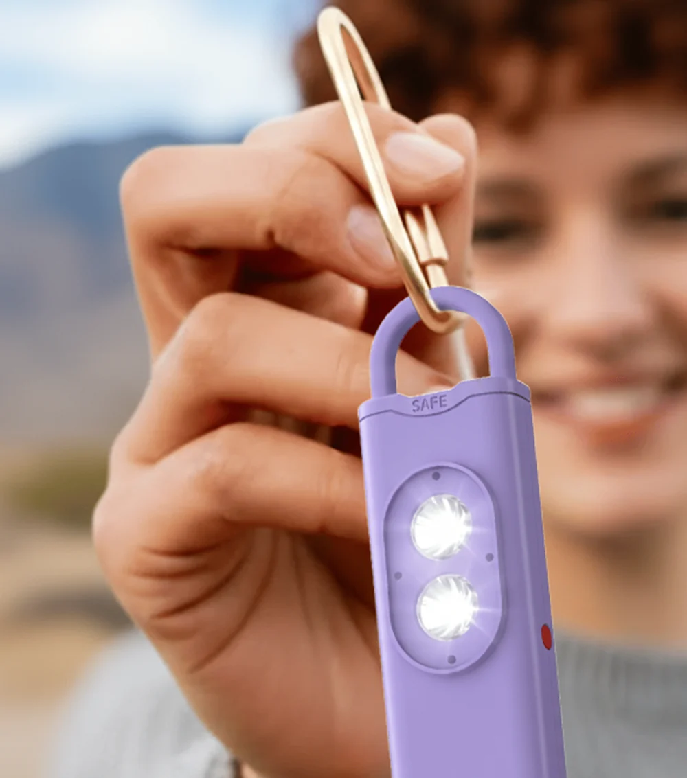 A woman holding a HaloSiren on her keychain